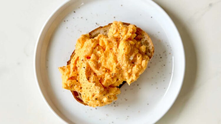 Confirmed by home cooks and chefs alike—a spoonful of this dairy product makes scrambled eggs more tender and silky